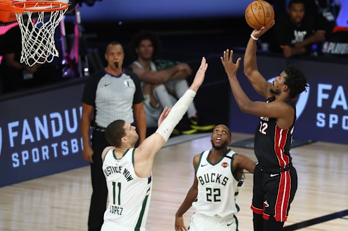 Miami Heat forward Jimmy Butler (22) shoots over Milwaukee Bucks center Brook Lopez (11) and forward Khris Middleton (22)
